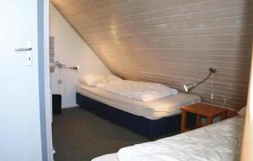 KemmerodeにあるFerienhaus 102 In Kirchheimのベッド2台と壁が備わる小さな客室です。