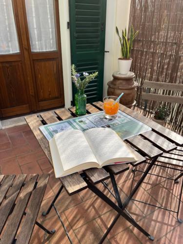 an open book on a table with a cup of orange juice at La Casina Verde in Siena