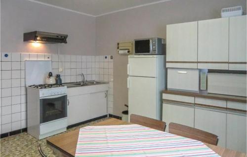 a kitchen with a table and a stove and a refrigerator at Awesome Apartment In Rodershausen With Wifi in Rodershausen