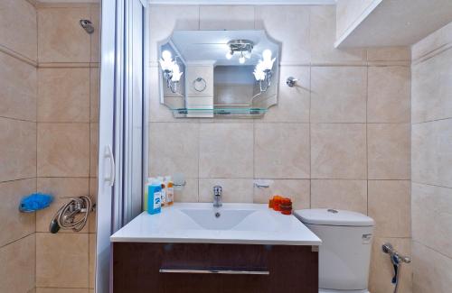 a bathroom with a sink and a toilet and a mirror at Aphrodite House in Chania
