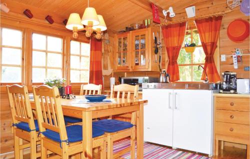 ノールハイムスンにあるBeautiful Home In Norheimsund With Wifiのキッチン(木製テーブル、椅子、冷蔵庫付)