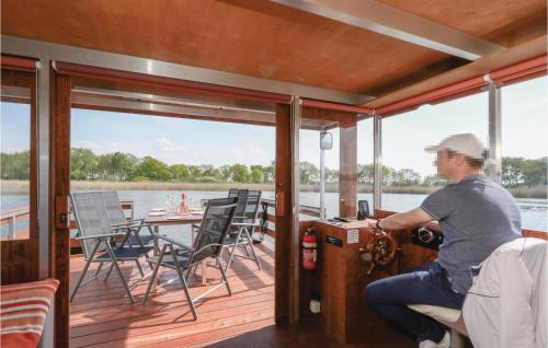 a man sitting on the deck of a boat at 2 Bedroom Awesome Ship In Neustrelitz in Buchholz