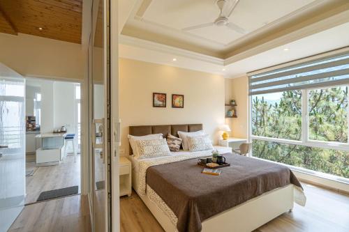 a bedroom with a bed and a large window at Pristine Pines by VEO - 8BR,2BR with Indoor Games at Kasauli in Kasauli