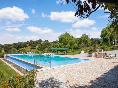 モンテモル・オ・ノボにあるCountry mansion in Montemor o Novo Alentejo with shared poolのパティオ付きの庭に大きなスイミングプールがあります。