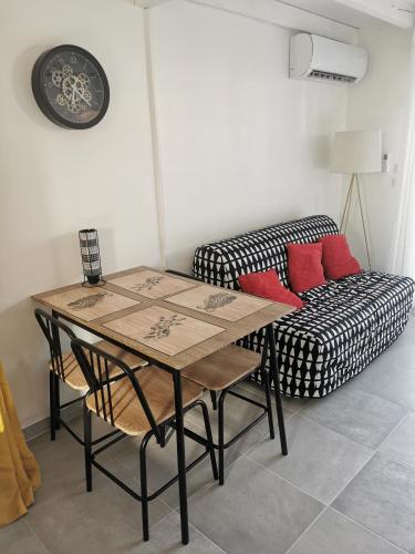 uma sala de estar com uma mesa e um sofá em Studio L'islois em LʼIsle-sur-la-Sorgue