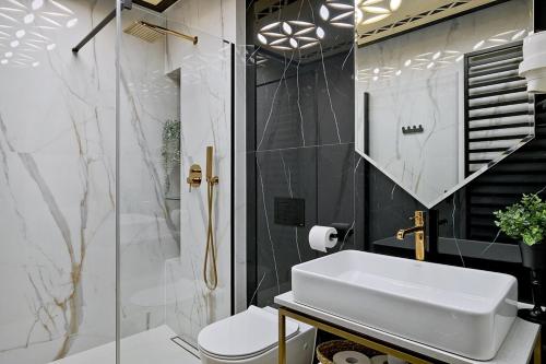 a bathroom with a white sink and a shower at Aparthotel Góralski Spa 2 in Białka Tatrzanska