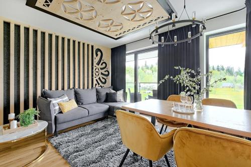 a living room with a couch and a table at Aparthotel Góralski Spa 2 in Białka Tatrzanska