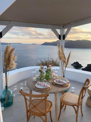 a table on a balcony with a view of the ocean at Aspaki by Art Maisons in Oia