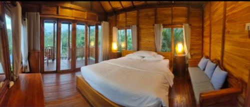 - une chambre avec un lit dans une pièce dotée de fenêtres dans l'établissement Umah Legenda Bali - Legend House Bali, à Tabanan