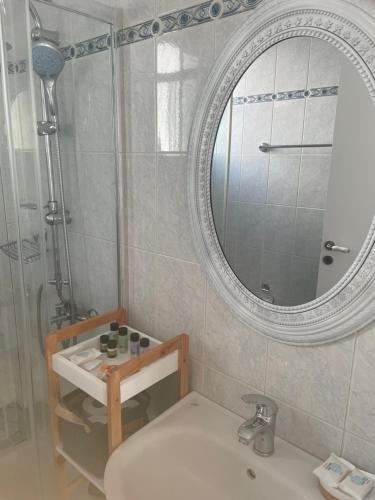 a bathroom with a sink and a mirror and a shower at Estella’s House in Livadia