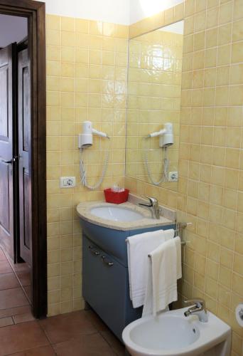 a bathroom with a sink and a toilet and a mirror at Appartamenti Ferrari Residence in Cannobio