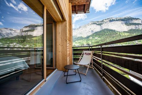 a chair on a balcony with a view of mountains at Flem Mountain Lodge in Flims