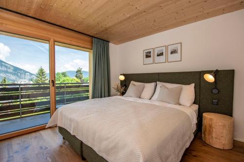 sypialnia z dużym łóżkiem i dużym oknem w obiekcie Flem Mountain Lodge w mieście Flims
