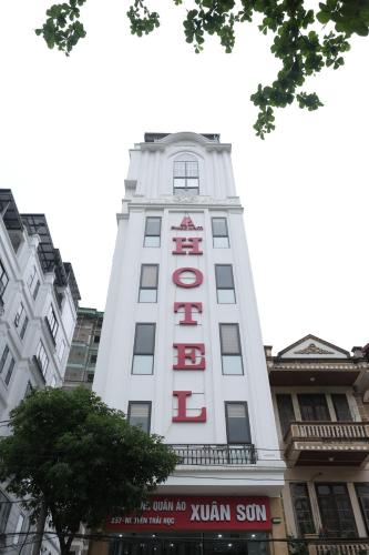 a tall white building with a red sign on it at Phúc Lâm Hotel in Ha Giang