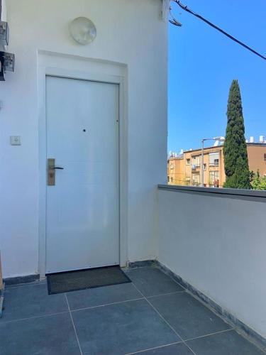 a white door in a room with a window at יחידות אירוח נוף המפרץ in Haifa