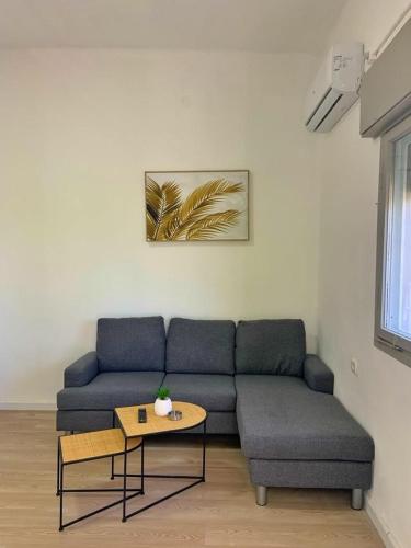 a living room with a blue couch and a table at יחידות אירוח נוף המפרץ in Haifa