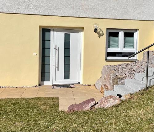 a house with a white door and a window at Haus Jenni im Schwarzwald, 3,5-Zimmer, große Terrasse in Freudenstadt