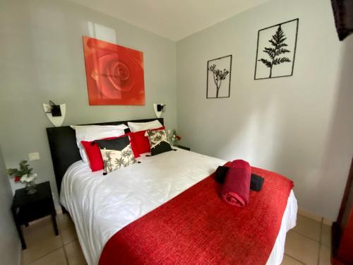 ein Schlafzimmer mit einem Bett mit einer roten Decke darauf in der Unterkunft appartement en residence au golf in Biscarrosse