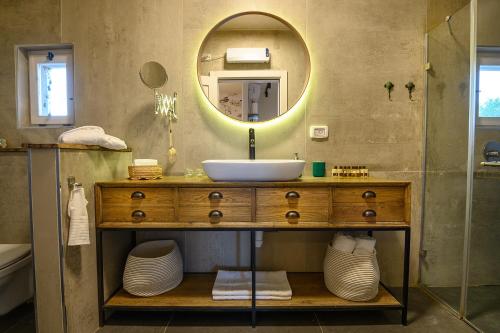 een badkamer met een wastafel en een spiegel bij אצל רנאטה in Abirim