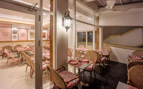 a restaurant with tables and chairs and a mirror at Heritage Village Resort & Spa Goa in Cansaulim