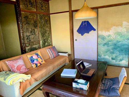 ein Wohnzimmer mit einem Sofa und einem Tisch in der Unterkunft Hanatsu in Tamano