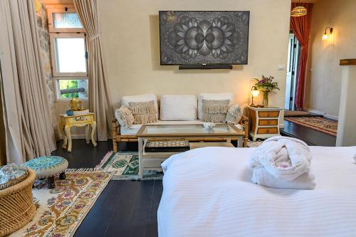 a bedroom with two beds and a table and a couch at אצל רנאטה in Abirim