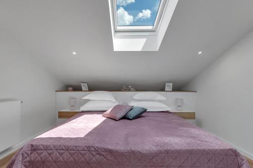 a bedroom with a large bed with a window at Luxury Penthouse - Big Blue in Tučepi