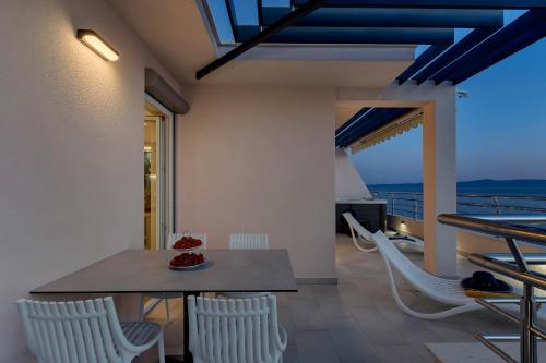 a dining room with a table and chairs on a balcony at Luxury Penthouse - Big Blue in Tučepi