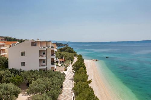 a building on a beach next to the ocean at Luxury Penthouse - Big Blue in Tučepi