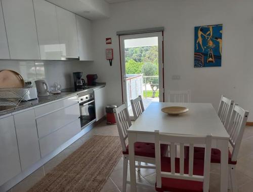a kitchen with a white table and a table and chairs at Casa Citrus Limão - Between the Hills & the Ocean in Silves