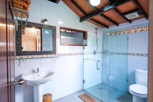 ein Badezimmer mit Glasdusche und Waschbecken in der Unterkunft Surfer Paradise Villas Bali in Canggu