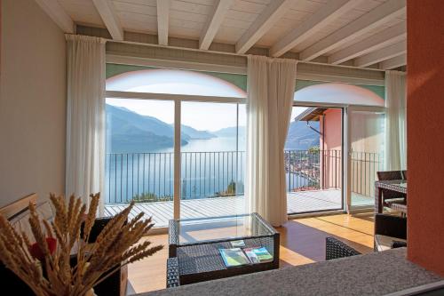 a living room with a glass table and a large window at Residence CaFelicita - Apartments Lake View - Infinity Pool - Jacuzzi in Gravedona