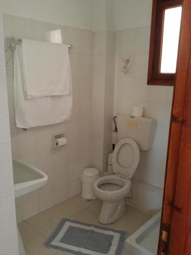 a white bathroom with a toilet and a bath tub at Ocean View in Kamari
