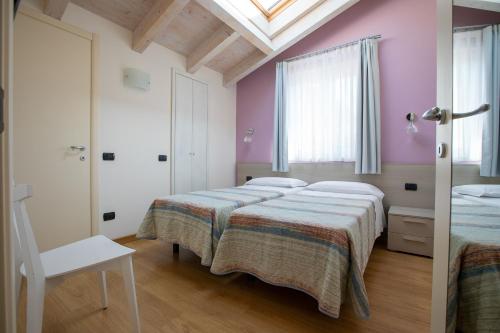 a bedroom with two beds and a chair in it at Residence CaFelicita - Apartments Lake View - Infinity Pool - Jacuzzi in Gravedona