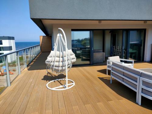 un porche con una sombrilla blanca en el balcón en AURA Delux Seaside, en Dziwnów