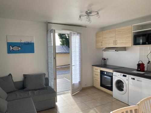une cuisine et un salon avec laveuse et sécheuse dans l'établissement Résidence Fort de l'Eve - T2 à 380m plage M Hulot et commerces - St Marc sur Mer idéal famille proche La Baule P0rnichet - Terrasse et parking privés, à Saint-Nazaire