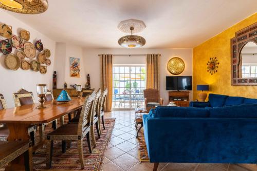 a living room with a table and a blue couch at Villa Oasis Galé - Luxury Villa with private pool, AC, free wifi, 5 min from the beach in Albufeira