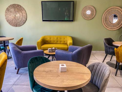 une salle d'attente avec des tables et des chaises et une télévision dans l'établissement Maria Stella, à LʼÎle-Rousse