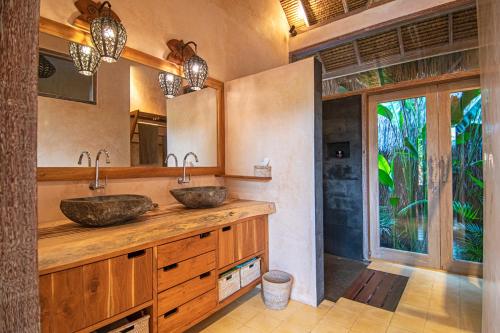 baño con 2 lavabos en una encimera de madera en Anahata - Tropical Private Villas, en Gili Air