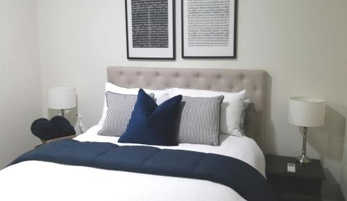 a bedroom with a large bed with blue pillows at Hunter Cottage Euroa in Euroa