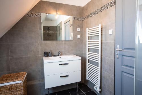 a bathroom with a sink and a mirror at Superbe maison avec piscine et jacuzzi dans les dunes in Ambleteuse