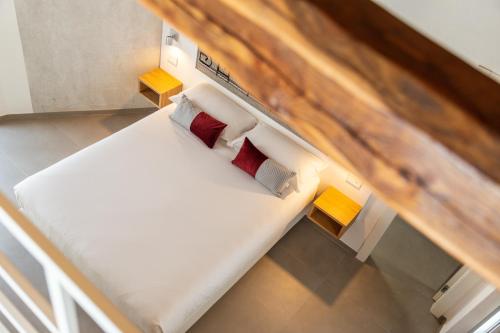 uma pequena cama com almofadas vermelhas num quarto em Domu Qirat - Authentic Rooms & Terraces em Tortolì