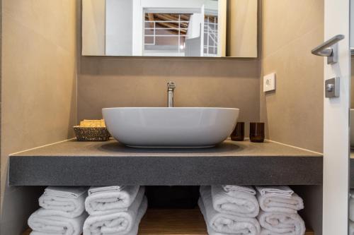 a bathroom with a sink and towels on a counter at Domu Qirat - Authentic Rooms & Terraces in Tortolì