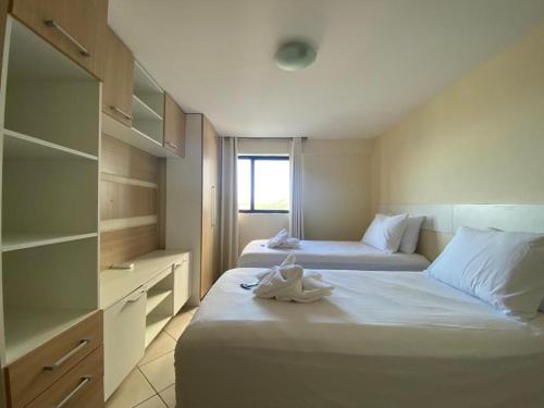 um quarto de hotel com duas camas com toalhas em Natal Plaza 604-Ponta Negra em Natal