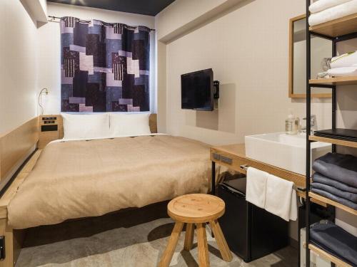 a small bedroom with a bed and a sink at Sakura Terrace The Atelier in Kyoto