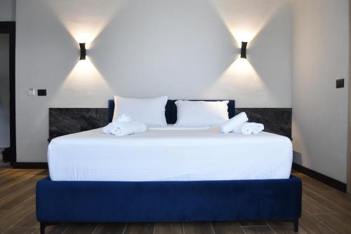 a bedroom with a large white bed with two lights at Gogo's Boutique Hotel in Dhërmi