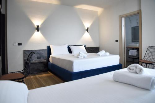 a hotel room with two beds with towels on them at Gogo's Boutique Hotel in Dhërmi