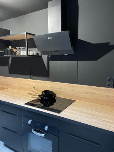 a kitchen with a counter with a stove top oven at PADDOCK 24 Arnage - Loft Le Mans in Arnage