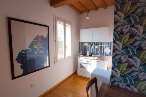 a kitchen with a table and a painting on the wall at L'Andito in Carpi