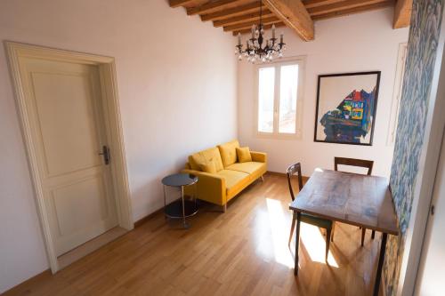 a living room with a yellow couch and a table at L'Andito in Carpi